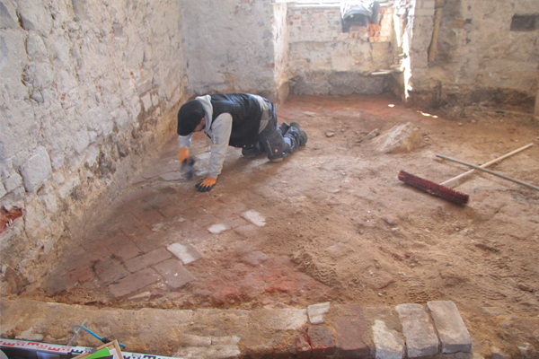 Präparieren eines Backsteinfußbodens des 18. Jahrhunderts im ehemaligen Getreidespeicher